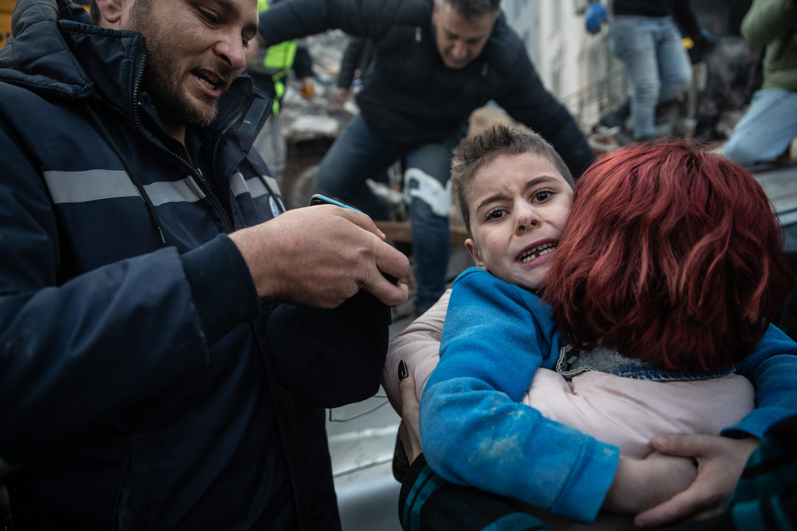 Dramatic photos show the moment an 8-year-old survivor was rescued and reunited with his mother
