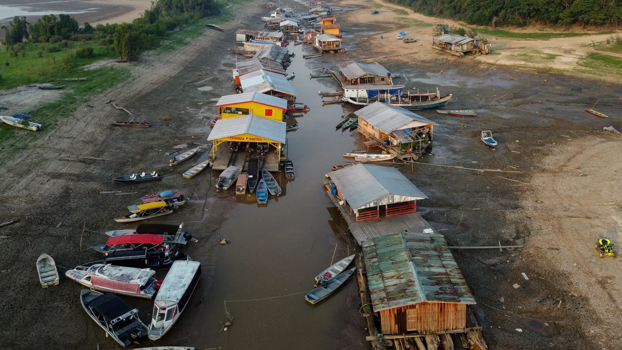 A floating village is stranded on a dry lakebed as extreme drought ...