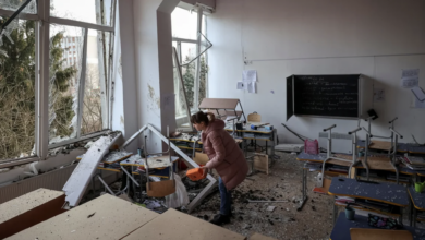 A woman inspects damage to a school in Lviv following Russian attacks on Thursday. Roman Baluk/Reuters