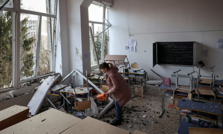 A woman inspects damage to a school in Lviv following Russian attacks on Thursday. Roman Baluk/Reuters