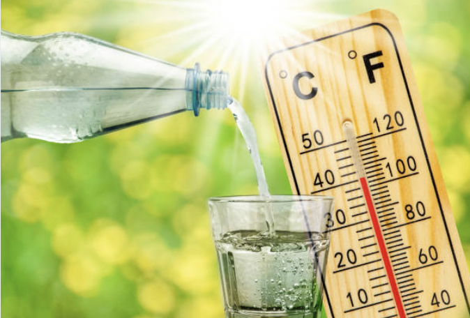 thermometer shows high temperature in summer heat and bottle with water and drinking glass
